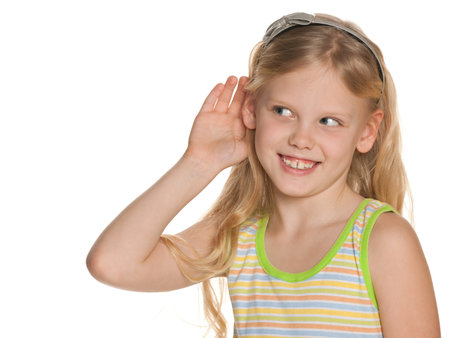 A young girl listening to something holding his hand to the ear; on the white background