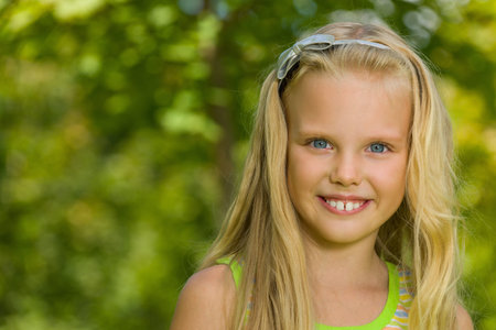 A portrait of a blonde yiung girl outdoors