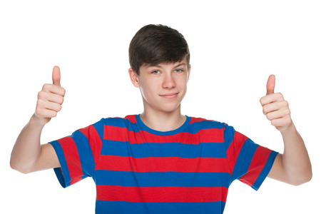 A teen boy holds his thumbs up on the white backgroundの写真素材