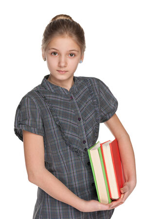 A clever preteen girl holds books against the white backgroundの写真素材