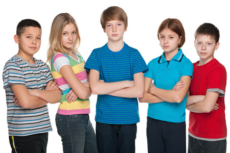 A group of five pensive children are standing on the white backgroundの写真素材