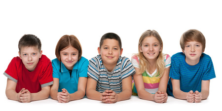 A group of five happy children are lying on the white backgroundの写真素材