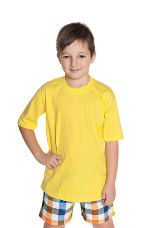 A portrait of a smiling little boy in the yellow shirt on the white backgroundの写真素材