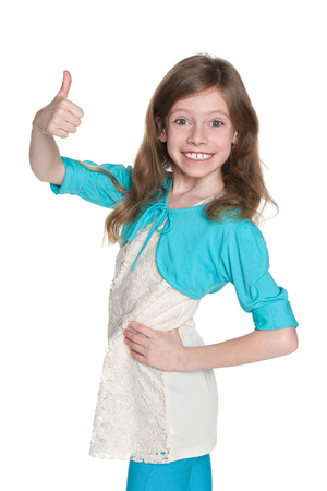 A profile portrait of a laughing young girl holding her thumb up on the white backgroundの写真素材
