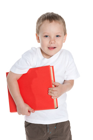 A closeup portrait of a cute preschool boy with a book on the white backgroundの写真素材