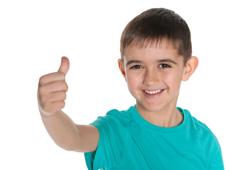 Young laughing boy holds his thumb up on the white backgroundの写真素材