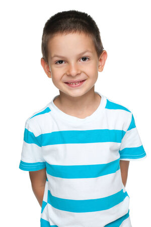 A portrait of a smiling little boy in the striped shirt against the white backgroundの写真素材