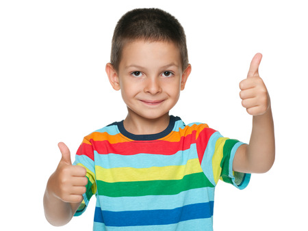 A cute little boy holds his thumbs up on the white backgroundの写真素材