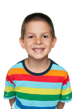 A portrait of a little cheerful boy in a striped shirt on the white backgroundの写真素材