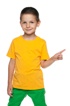 A little boy shows his finger to the side against the white backgroundの写真素材
