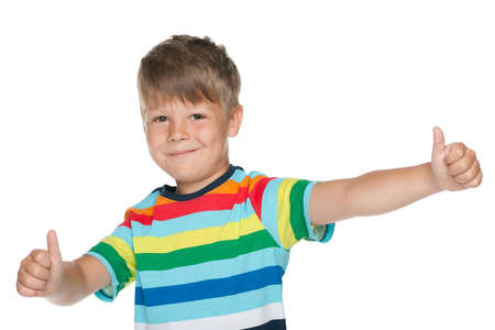 A cheerful little boy holds his thumbs up on the white backgroundの写真素材
