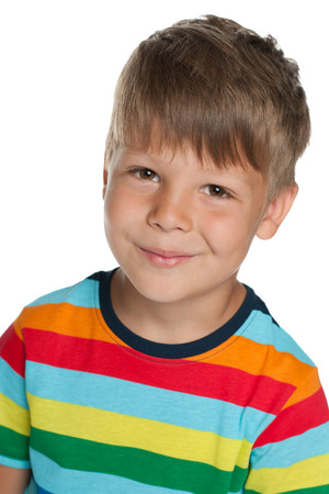 A closeup portrait of a little cheerful boy in a striped shirt on the white backgroundの写真素材