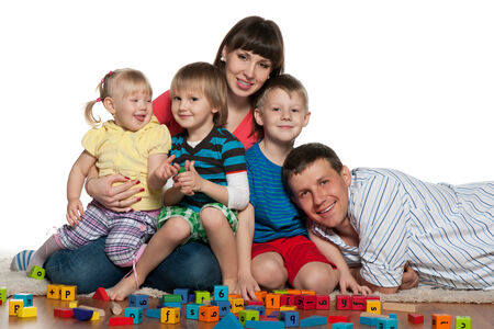 A family with children are playing on the floorの写真素材