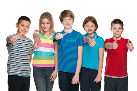 Portrait of a group of five happy children holding his thumbs up on the white backgroundの写真素材