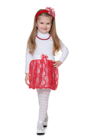 A smiling little girl walks against the white backgroundの写真素材