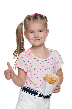 A pretty little girl with fries holds his thumbs up on the white backgroundの写真素材