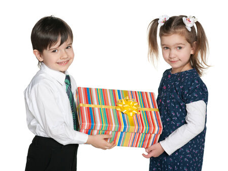 Two smiling children hold a gift box against the white backgroundの写真素材