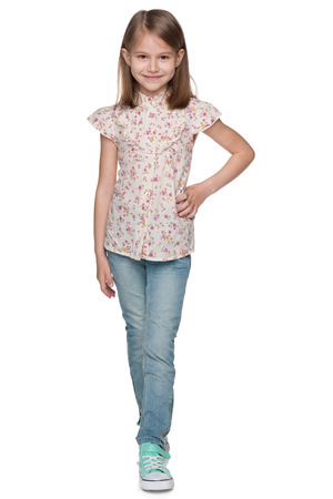 A portrait of a smiling walking little girl on the white backgroundの写真素材