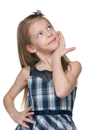 A pensive little girl looks up on the white backgroundの写真素材