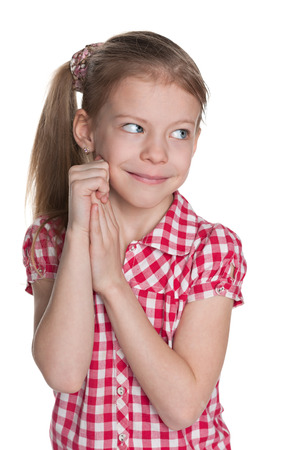 A portrait of a shy pretty little girl against the white backgroundの写真素材