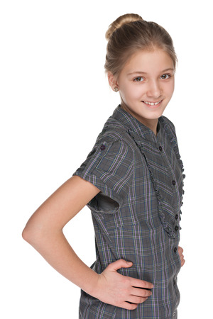 A profile portrait of a smiling pretty preteen girl against the white backgroundの写真素材