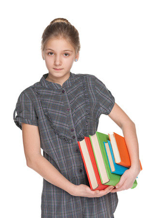 A clever young girl holds books against the white backgroundの写真素材