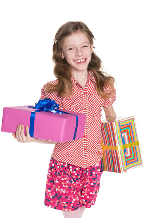 A happy little girl holds gift boxes against the white backgroundの写真素材