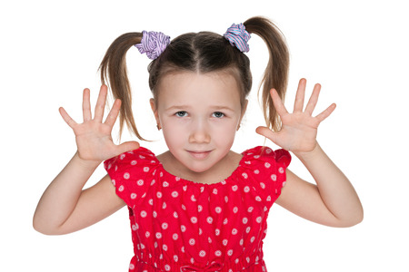 A smiling little girl is showing her hands on the white backgroundの写真素材