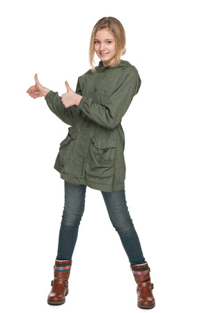 A smiling preteen girl holds his thumbs up on the white backgroundの写真素材