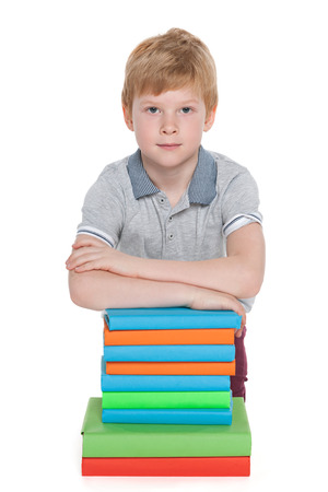 A clever young boy with a pile of books on the floorの写真素材