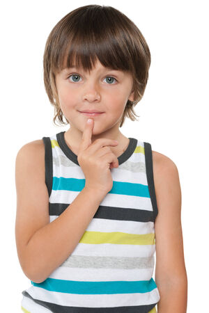 A portrait of a curious little boy in a striped shirt on the white backgroundの写真素材