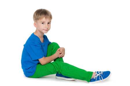 A smiling little boy sits on the white backgroundの写真素材