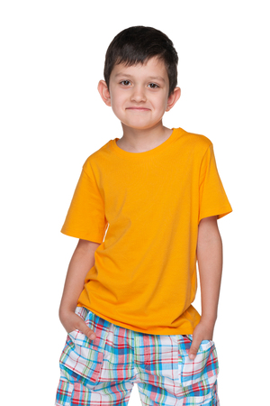 A portrait of a naughty young boy in a yellow shirt on the white backgroundの写真素材