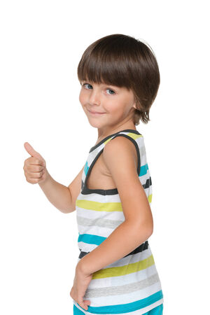 A cute young boy with his thumb up looks backの写真素材