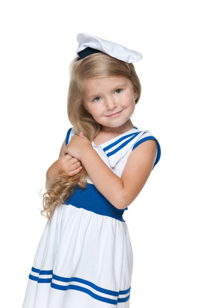 An adorable little girl in a fashion dress is standing on the white backgroundの写真素材