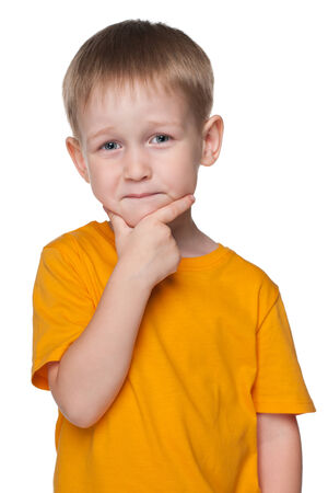 A portrait of a cute little boy in a yellow shirt against the white backgroundの写真素材