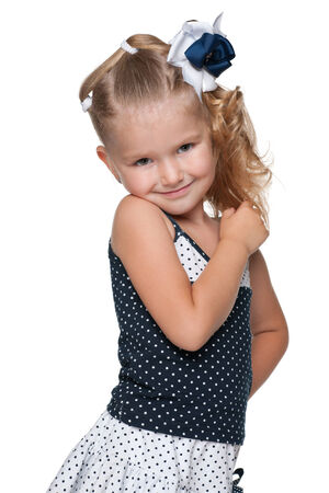 A portrait of an adorable little girl in a fashion dress on the white backgroundの写真素材