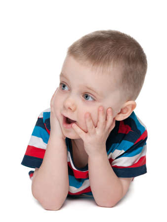 A surprised little boy is lying on the white backgroundの写真素材