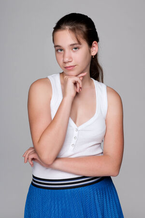 A portrait of a pensive pretty teen girl against the gray backgroundの写真素材