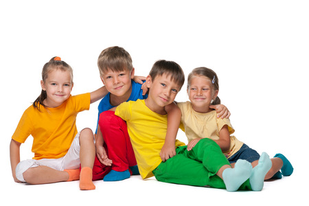 Four fashion cheerful children sit on the white backgroundの写真素材