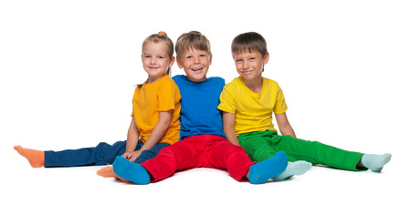 Three cheerful children sit on the white backgroundの写真素材