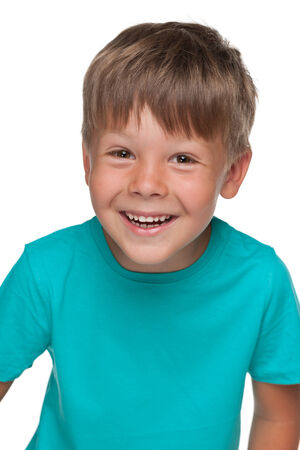 A portrait of a cheerful little boy in a blue shirt on the white backgroundの写真素材