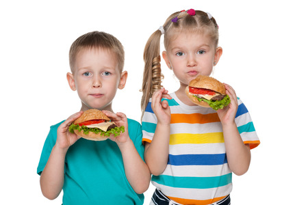 Two children with hamburgers on the white backgroundの写真素材