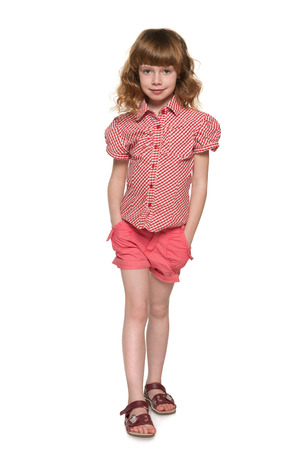 A pretty little girl is standing on the white の写真素材