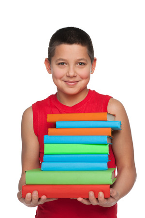 A happy preteen boy holds books against the white の写真素材