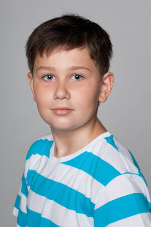 A confident young boy against the gray の写真素材