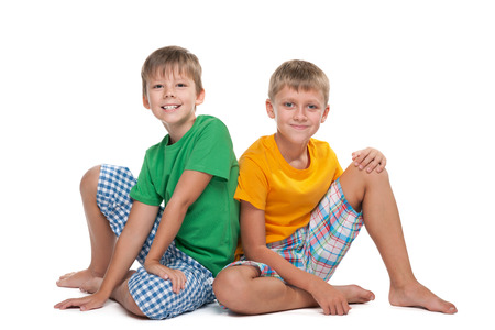 Two young handsome boys sit together on the white の写真素材