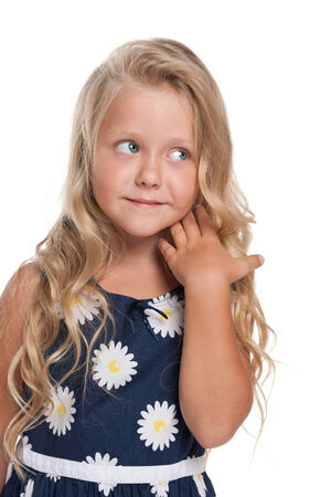 A portrait of a pensive little blonde girl against the white の写真素材