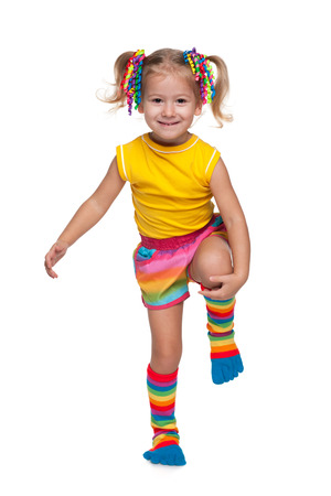 A cute little girl is standing against the white の写真素材