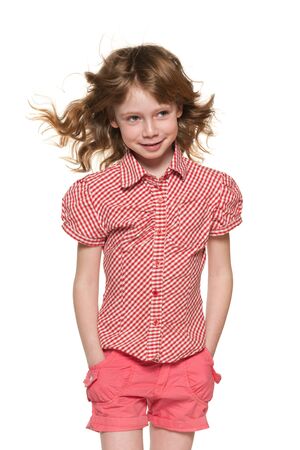 A portrait of a cheerful little girl with flowing hair on the white backgroundの写真素材